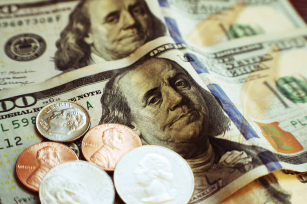 Passive Income Through Stock Dividends With Pennies, Dime & Quarters On One Hundred Dollar Bills High Quality Passive Income Through Stock Dividends With Pennies, Dime & Quarters On One Hundred Dollar Bills minimum wage stock pictures, royalty-free photos & images