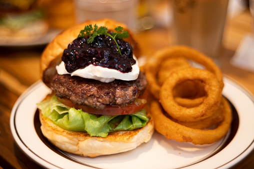 100% beef blueberry cream cheese hamburger plate with onion rings.