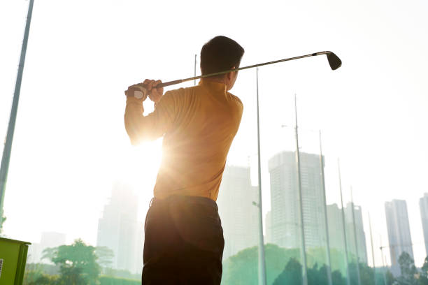 istock rear view of Asian man practicing golf swing 1309516070