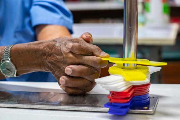 terapia ocupacional: el entrenamiento de la función de la mano en un paciente de accidente cerebrovascular mediante el uso de tubos metálicos de una sola curva y pinto mejoran su rehabilitación de la mano. - occupational therapy fotografías e imágenes de stock