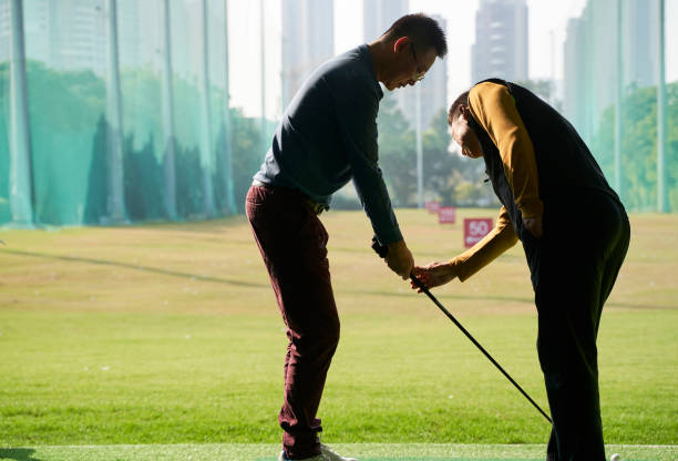 visão traseira do treinador ensinando homem asiático praticando balanço de golfe - golf lifestyles sport golf swing - fotografias e filmes do acervo
