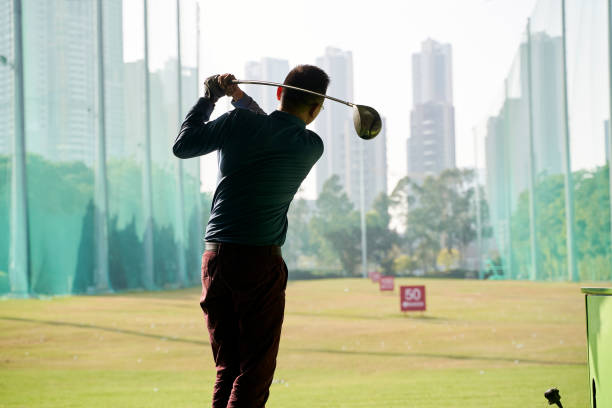 istock rear view of Asian man practicing golf swing 1309516158