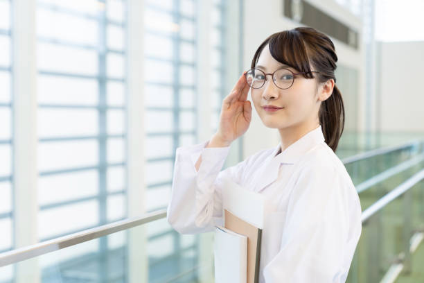 young asian woman wearing a white robe. medical school student. science school student. - women scientist indoors science imagens e fotografias de stock