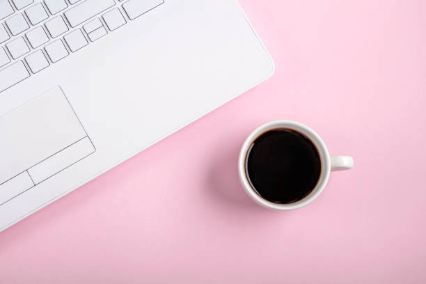 istock Flat lay workspace table with white laptop computer and cup of coffee on pink background. Copy space for text, minimalism. 1309519338