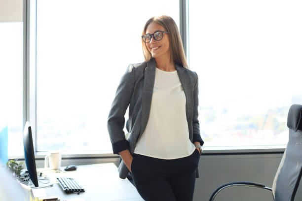 istock Attractive business woman smiling while standing in the office. 1309519429
