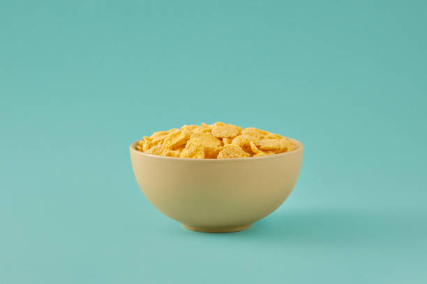 istock Traditional breakfast with cornflakes. Cornflakes in a light bowl on a colored turquoise background. 1309522011