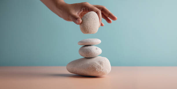 istock Life Balance Concept. Hand Setting White Natural Zen Stone Stack. Balancing Mind, Soul and Spirit. Mental Meditation Practice 1309526283