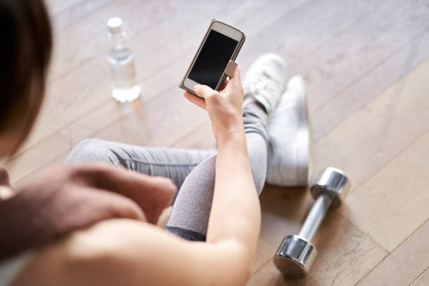 istock Asian woman watching training app on smartphone 1309526303