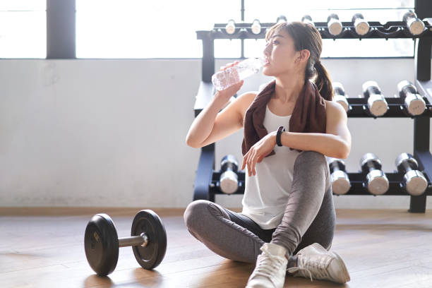 asiatische frau macht eine pause im trainingsgymnasium - japanese ethnicity train women asian ethnicity stock-fotos und bilder