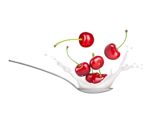 istock Cherries with milk splash in spoon on white background 1309531405