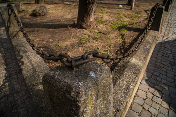 istock a fence with a rusty chain near a stone road, 1309531466