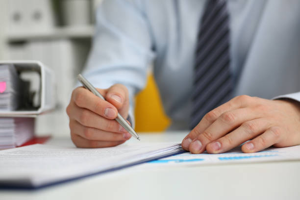 istock Male doing paper work in office with pen 1309534599
