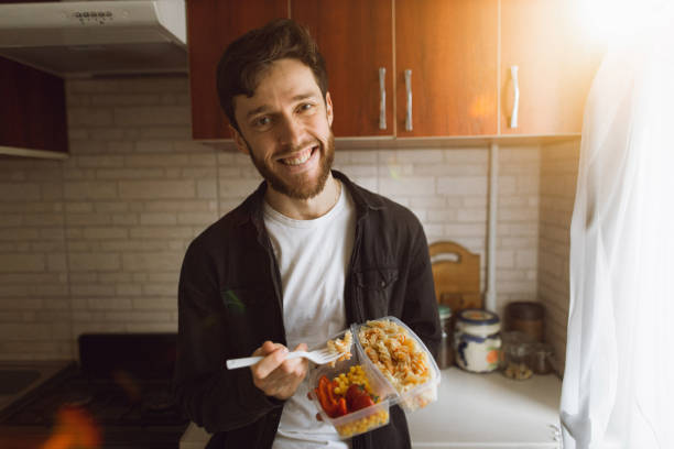 istock A young smiling man having lunch in the kitchen 1309535572