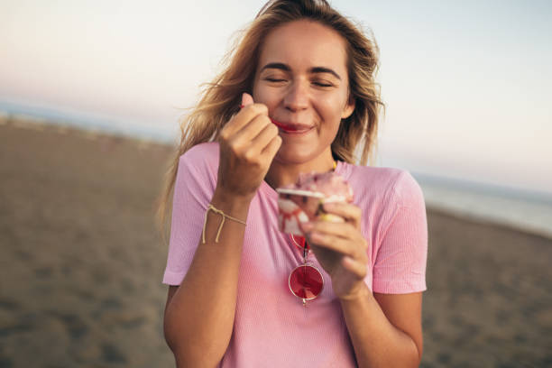 istock Girl eating ice cream on the beach 1309538101