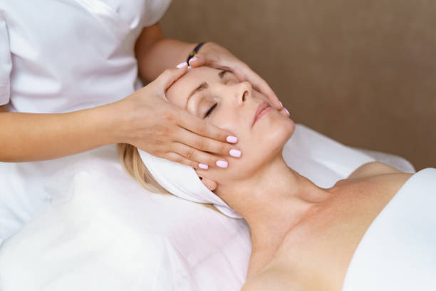 trattamento di bellezza del massaggio facciale. - massaging facial massage beautician beauty treatment foto e immagini stock