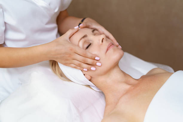 Facial massage beauty treatment. Face massage. Close-up of adult woman getting spa massage treatment at beauty spa salon. Spa skin and body care. Facial beauty treatment. Cosmetology. Mask stock pictures, royalty-free photos & images