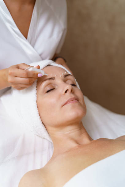 istock Cosmetologist applying cream on face 1309538984