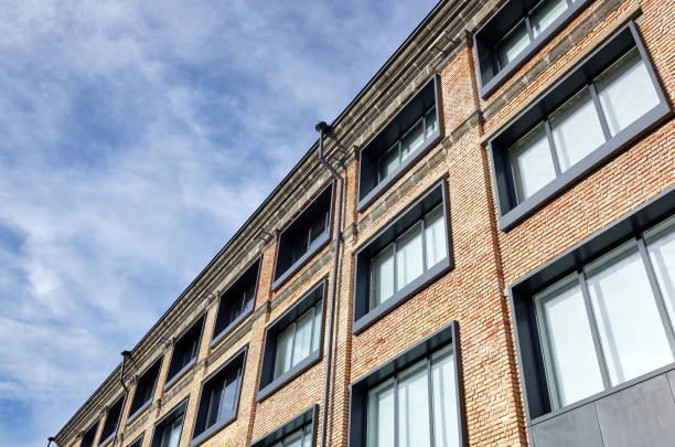 istock Brick building with windows and downspout against blue sky 1309539967