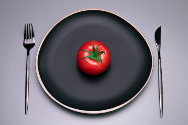 istock Tomato on the black plate. The concept of diet. 1309541992