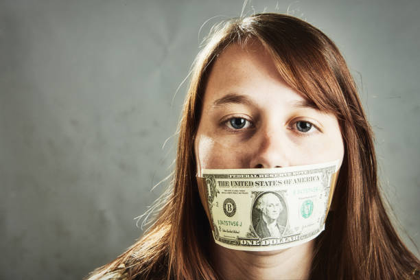 femme bâillonnée par un billet de 1 $, symbolisant la censure, la corruption ou un piège de la dette - currency silence censorship behavior photos et images de collection