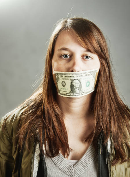 kobieta zakneblowana banknotem o nominale 1 usd, symbolizującym cenzurę, korupcję lub pułapkę zadłużenia - currency silence censorship behavior zdjęcia i obrazy z banku zdjęć