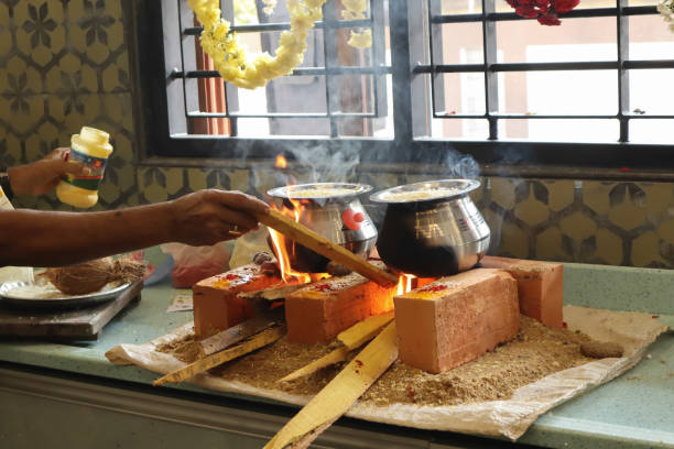 una escena de ceremonia de calentamiento de la casa en la cultura india donde un leña de fuego se enciende en una estufa de cambio para preparar dulces por primera vez en karnataka. - praying human hand worshipper wood fotografías e imágenes de stock