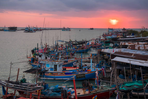 istock Fishing boat and cargo ship at sunrise in Cha-Am 1309548596