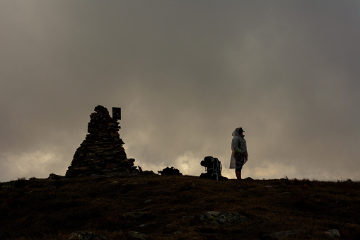 Couple of tourists in the clouds on top of Mount Brebeneskul, tourists standing on top in the raincoats, gloomy weather.2020