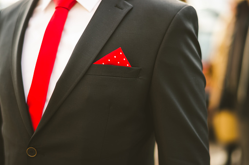 Black groom's dress with a red tie and red pocket square