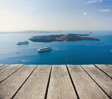 View from a wooden deck over beautiful island Nea Kameni on Santorini, Greece