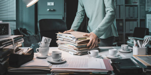 istock Office working carrying a pile of paperwork 1309549639