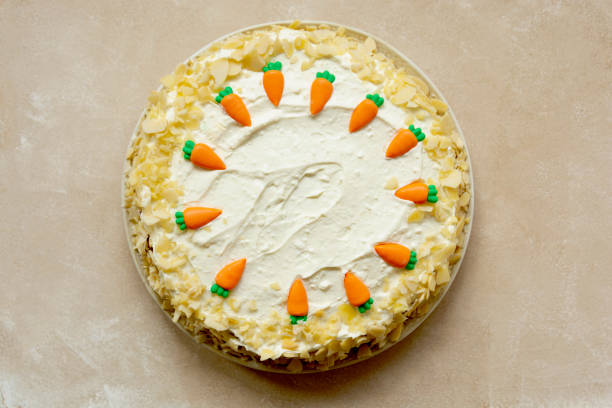 istock Carrot cake with walnuts an whipped cream, homemade easter cake baking, top view. Whole round cake. 1309549915
