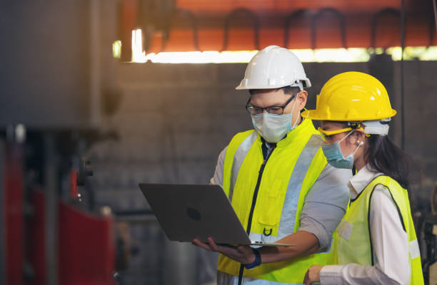 istock Two engineer in hard hat wearing safety using laptop for planning a project. Foreman explaining machinery to female employee 1309549923