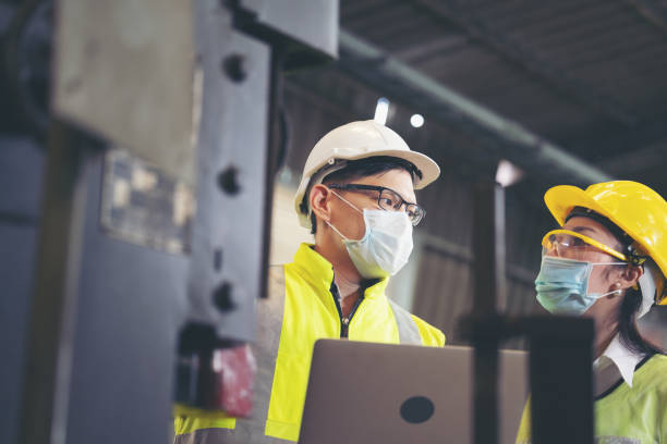 istock Two engineer in hard hat wearing safety using laptop for planning a project. Foreman explaining machinery to female employee 1309550799