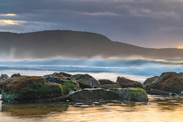 istock Sunrise seascape with rain clouds on the horizon 1309553344