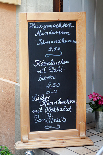 Chalkboard with menu and german food at door of restaurant bistro in Koblenz