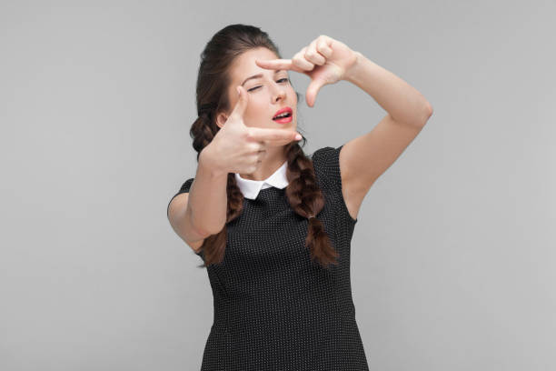 jeune femme bien rectifiée affichant le signe et le clin d’oeil de cadre. - looking at camera facial expression gesturing touching photos et images de collection