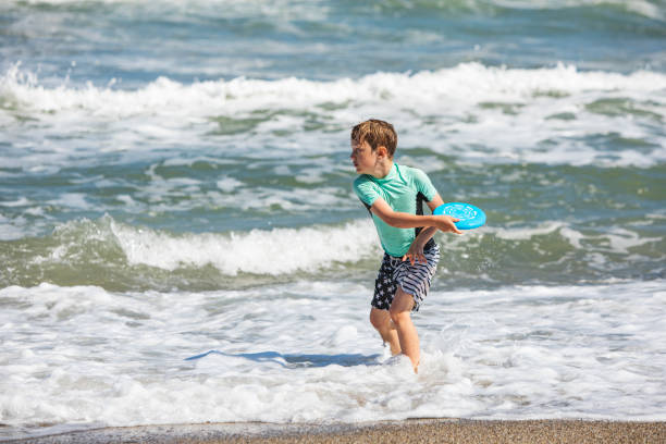 istock Father and son playing frisbee at the beach 1309560338