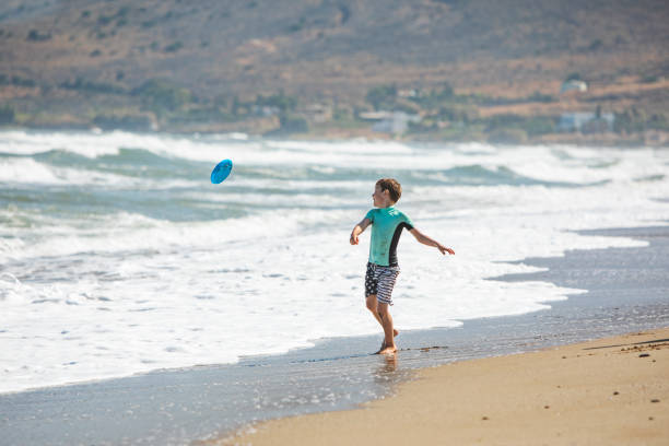 istock Father and son playing frisbee at the beach 1309560363
