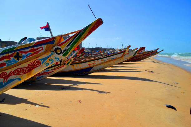 The colorful wooden boats in Saint Louis in Senegal The former capital of Senegal with its colorful fishing boats senegal beach stock pictures, royalty-free photos & images