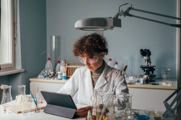 istock Woman Scientist in a Lab Coat Using a Digital Tablet During Research 1309560491
