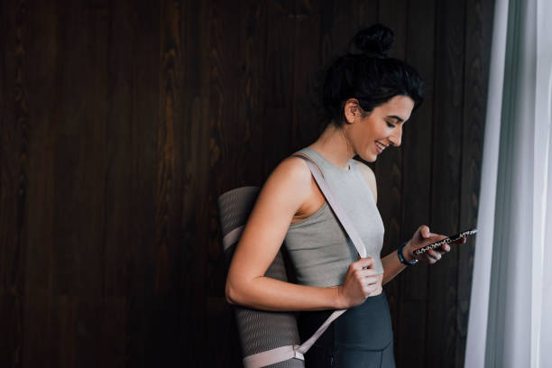 Young happy fit woman texting with her friends (copy space)