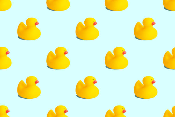 istock Yellow rubber duck toys seamless pattern isolated on pastel blue background. Opposition symbol and political struggle minimal concept. 1309561701