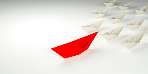 istock Innovative business solution concept. Group of white paper ships in one direction and leading one red paper ship 1309562192
