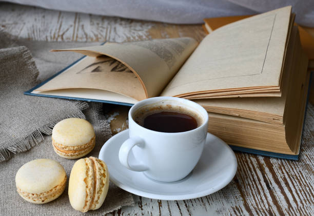 istock Cup of coffee, makroons and a book on the table. 1309562823