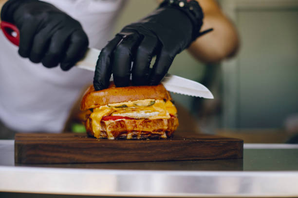 istock chef in black gloves cuts a burger with his knife 1309564265