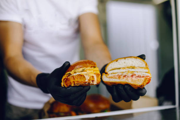 istock man in black gloves holds a burger cut in half 1309564488