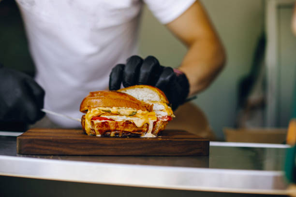 istock man in black gloves holds a burger cut in half 1309564523