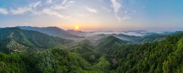Photo of Panoramic landscape view of sunrise or sunset over mountain and misty.
