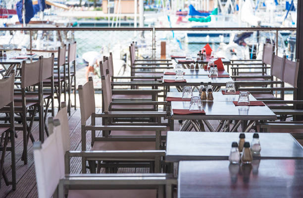 istock Empty tables in restaurant outdoors in front of the yachts harbor 1309568032
